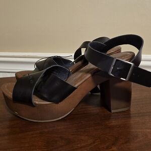 Black wedge style sandle with heel. Never worn.
